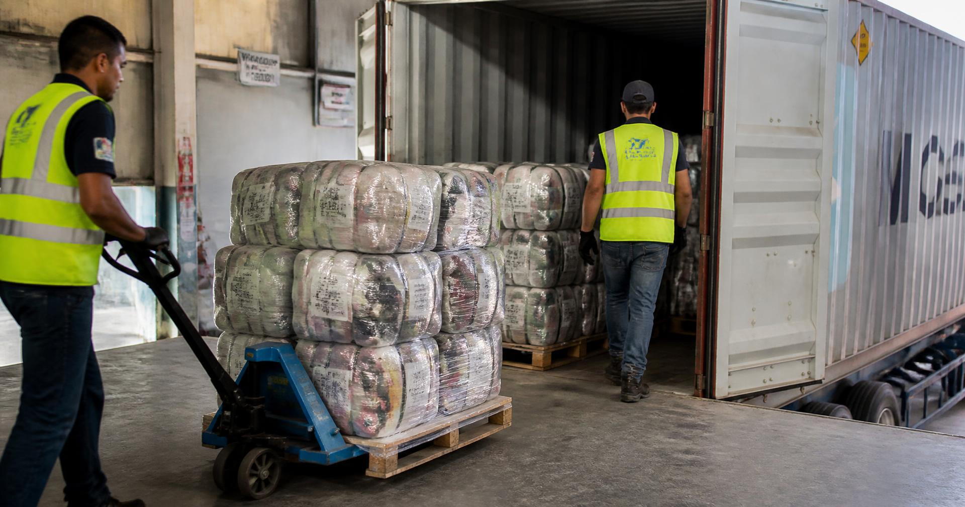 Used-clothing bales being loaded into a shipping container